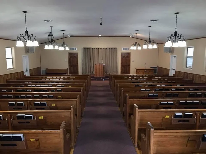 Rows of wooden pews face the pulpit in the auditorium at 50th Street Church of Christ.